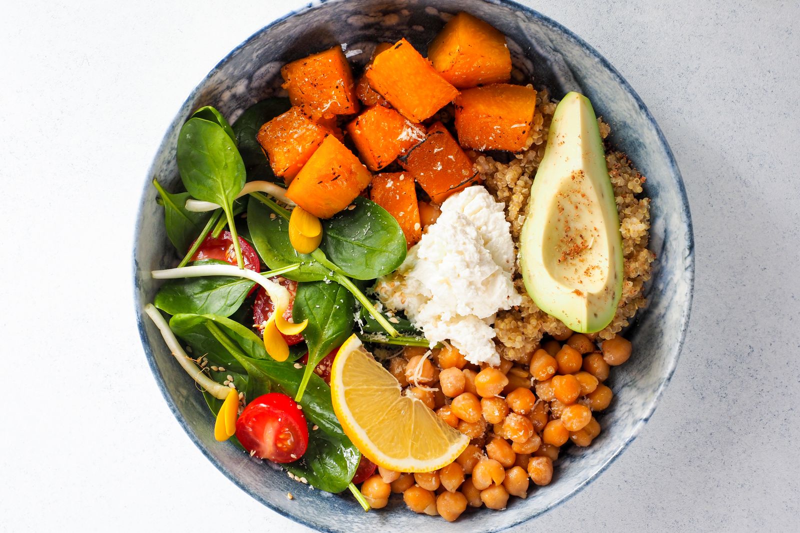 A colourful, balanced lunch bowl with vegetables, quinoa and avocado.