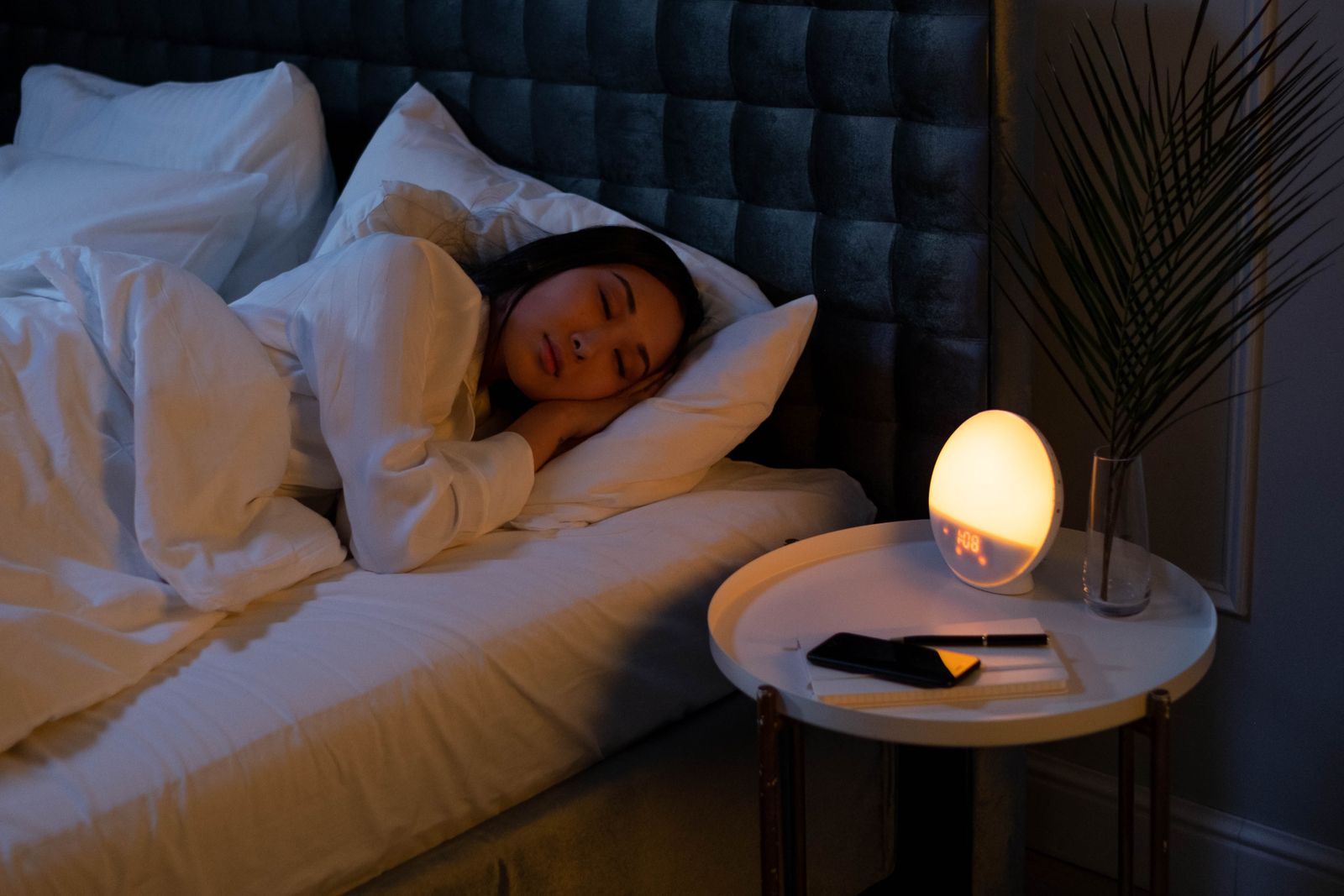 A person sleeping peacefully in bed in soft morning light.