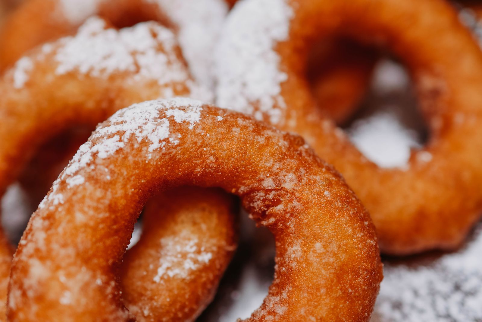 An assortment of sugary doughnuts covered in sugar.