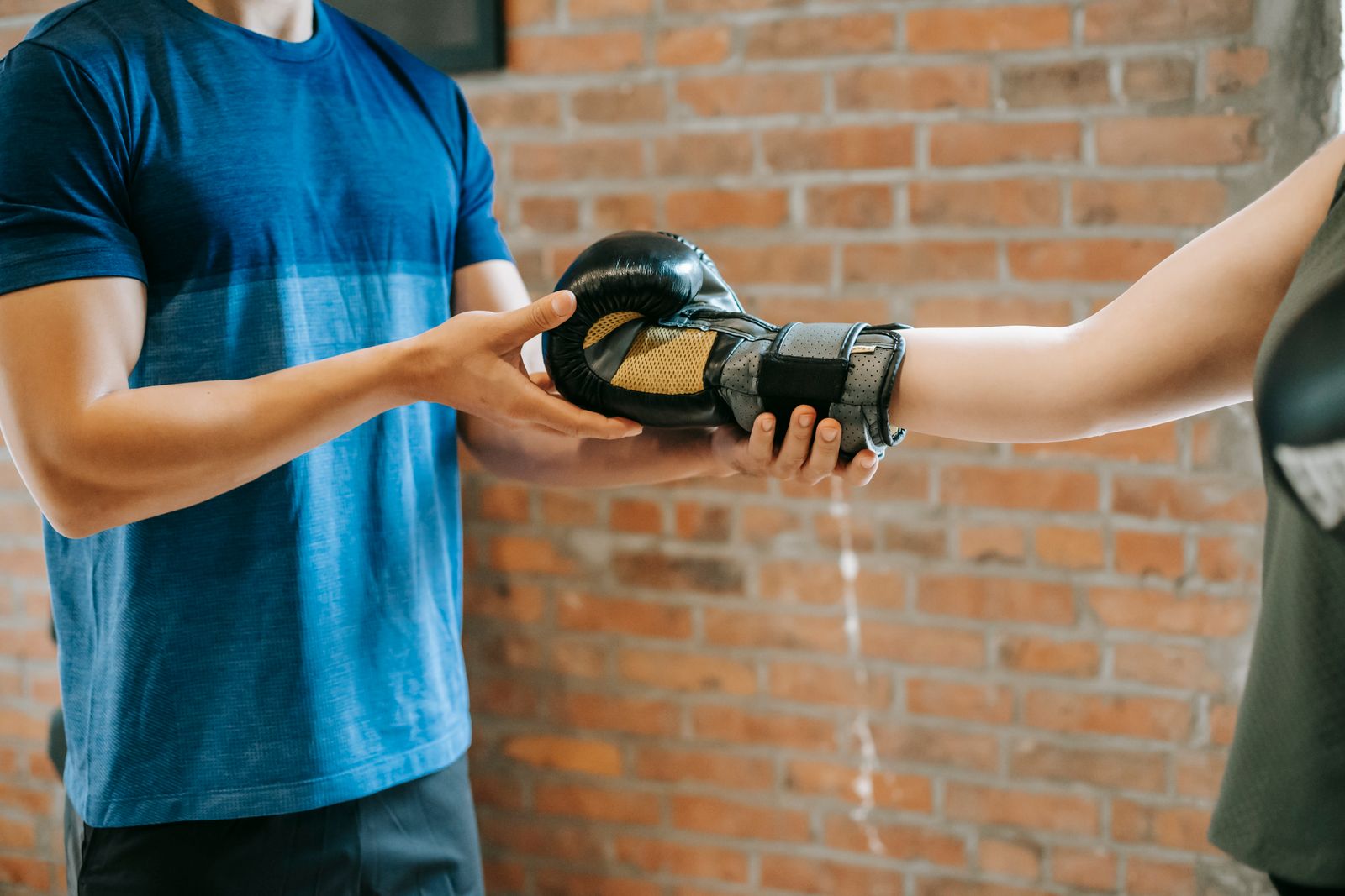 A coach guiding a client through a training session in a gym.