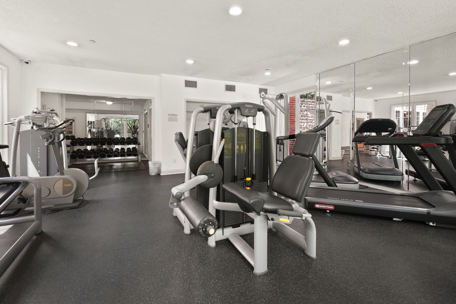 An empty gym interior, the equipment sitting unused in daylight.