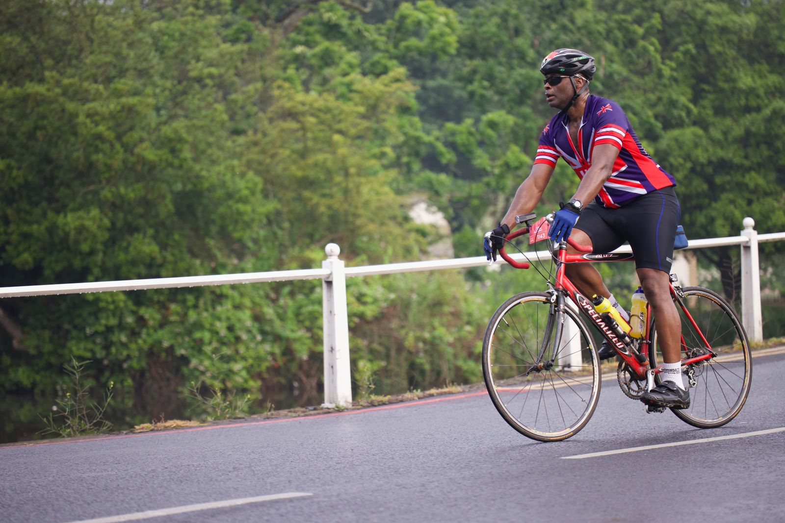 A cyclist riding at a steady pace along a scenic road.