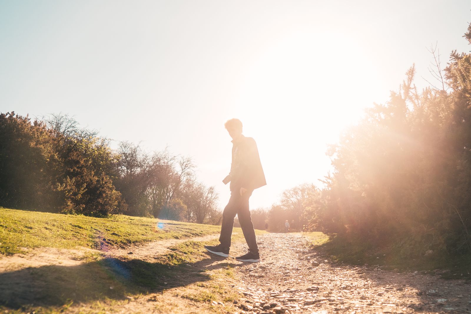 A person walking outdoors on a bright, sunny day.